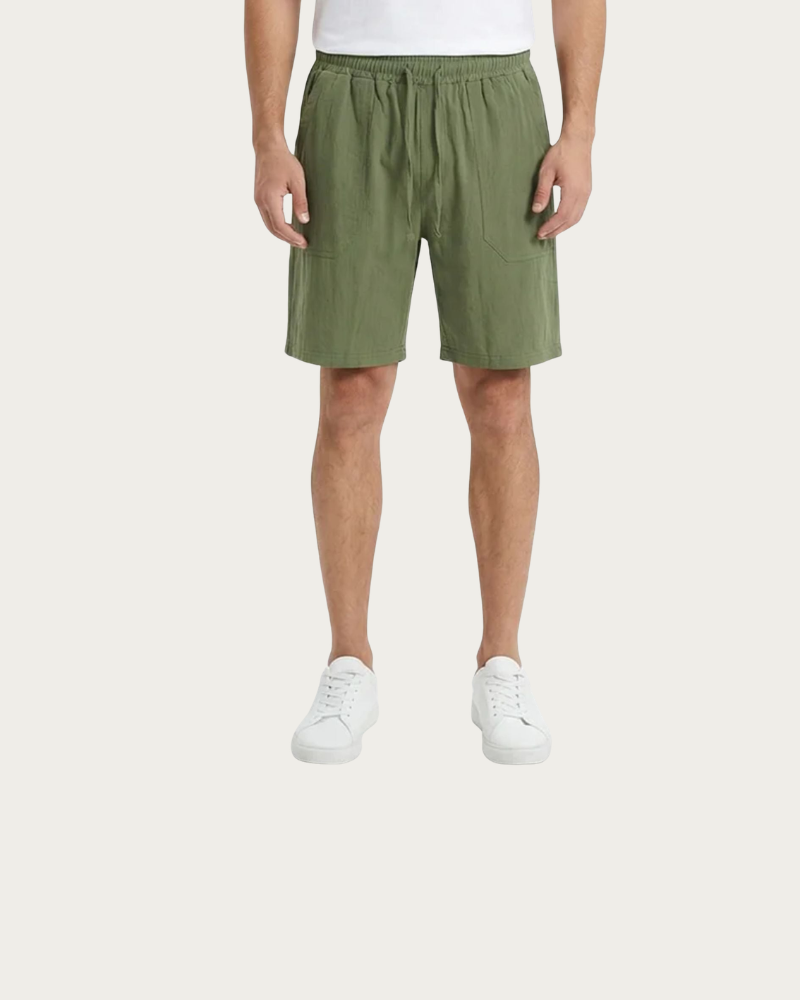 man wearing green linen shorts casual summer outfit front view