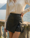 woman wearing black leather skort with white shirt outdoor setting