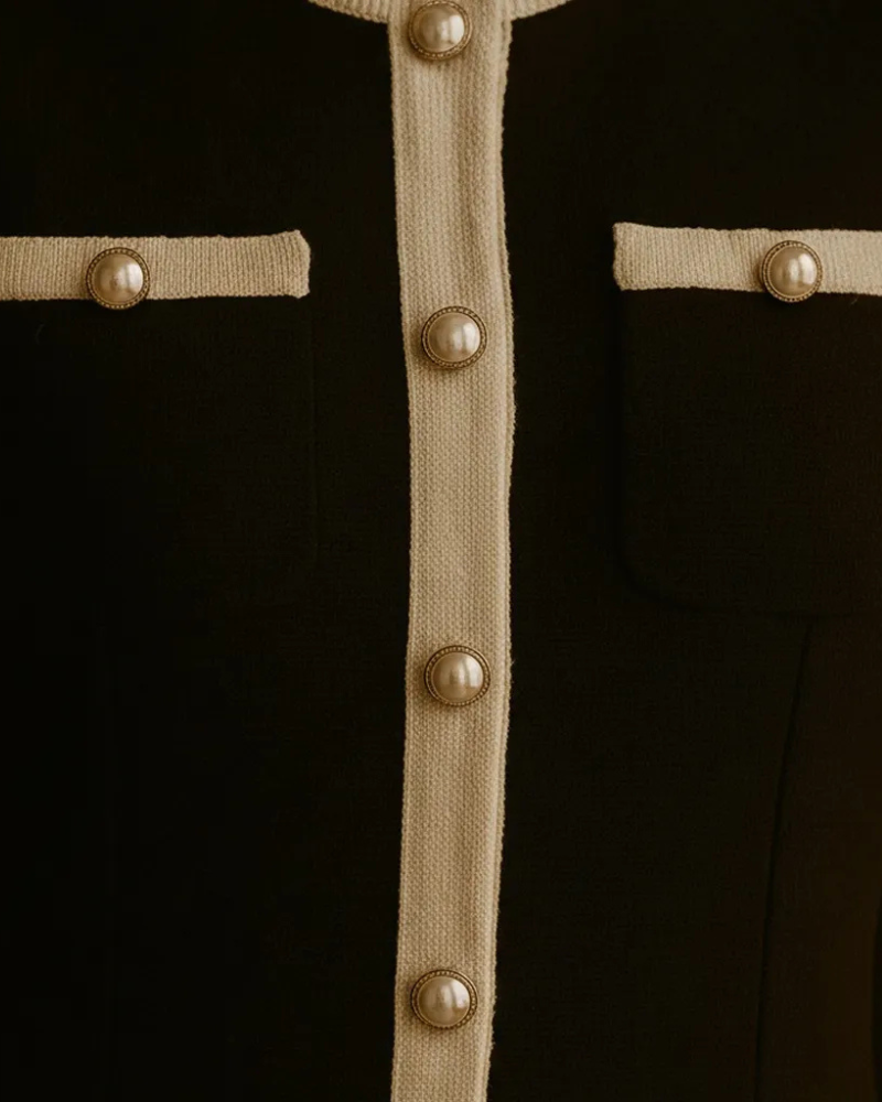 close up of black knit dress front buttons and contrast trim detail