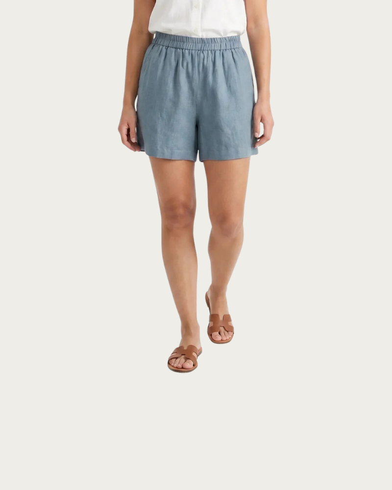 woman wearing light blue linen shorts relaxed summer outfit