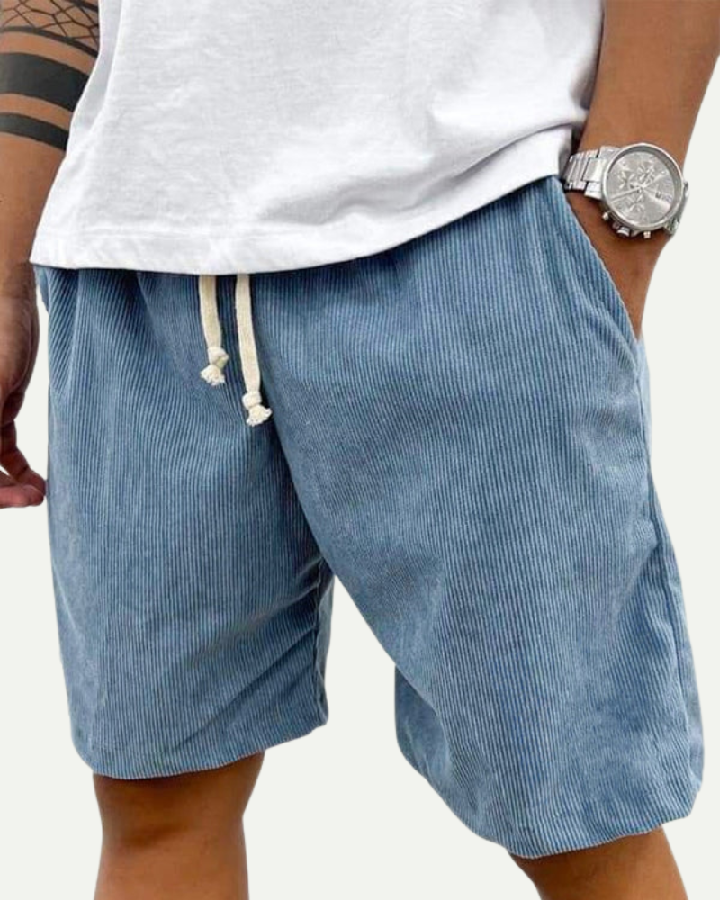 man wearing blue corduroy shorts casual summer outfit front view
