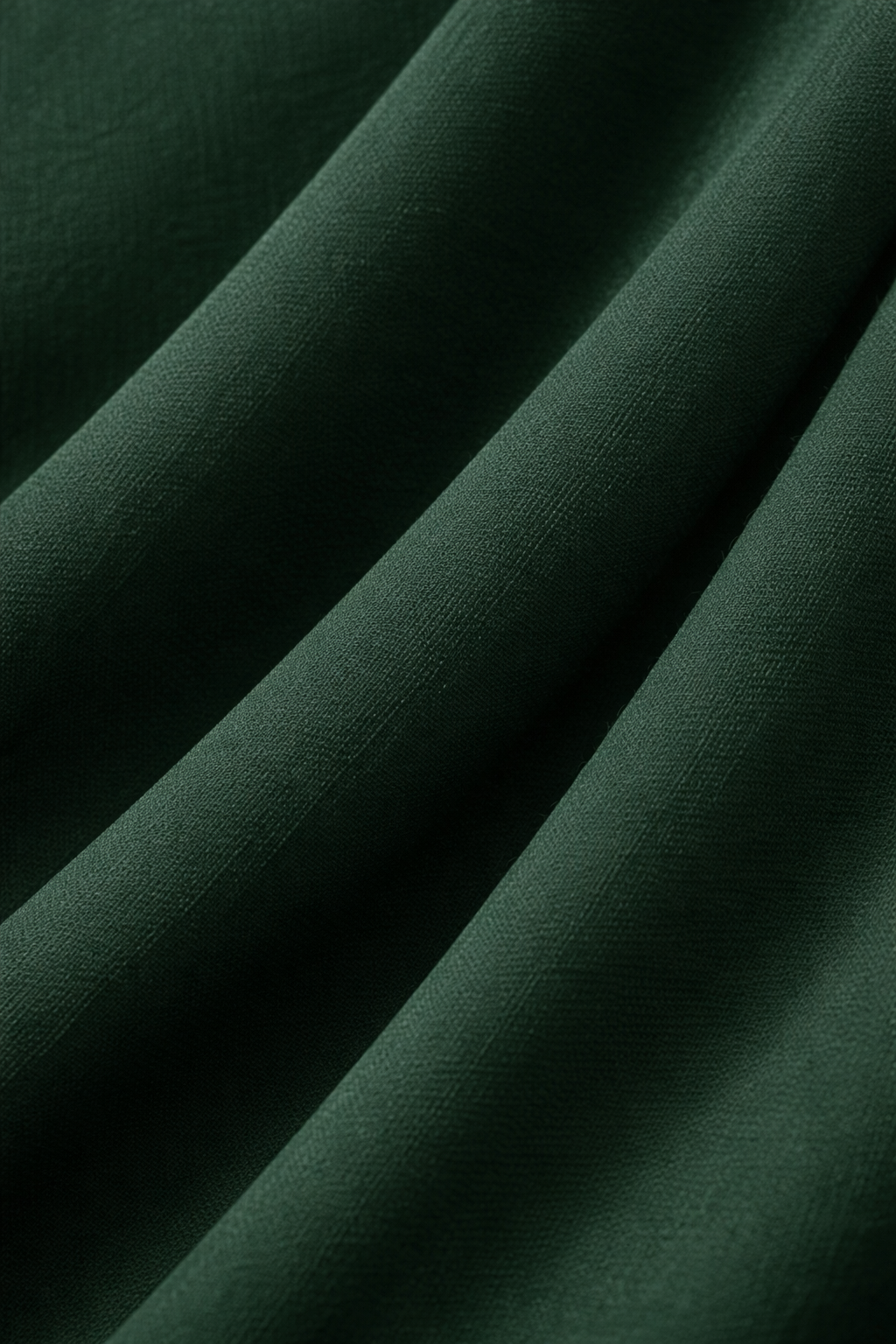 Close-up of dark green fabric with folds
